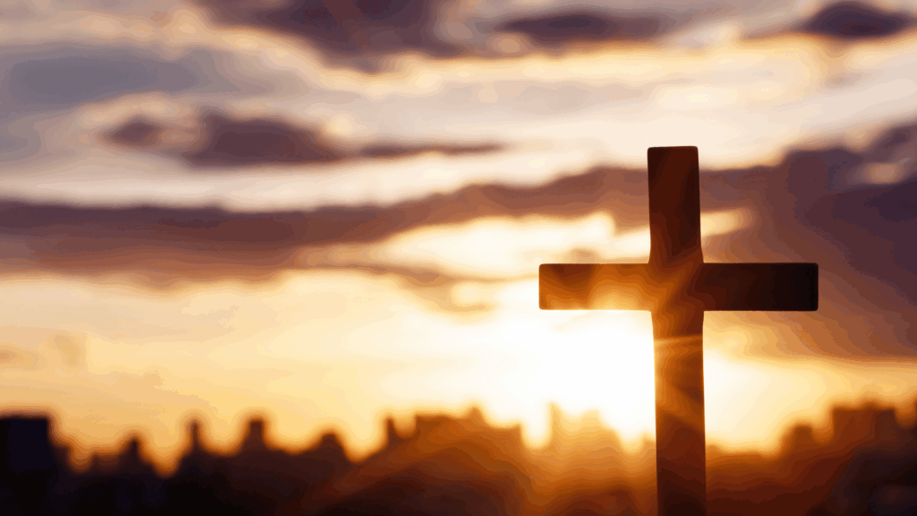 Cross with the background of a city scape at sunset